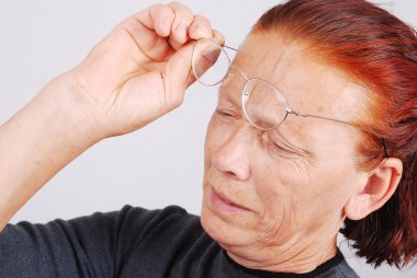 Elderly woman has a problem with sight, glasses do not help clipart