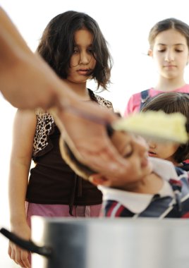 Hungry children in refugee camp, distribution of humanitarian food clipart