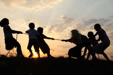 siluet, grup mutlu çocuklar oynarken çayır, günbatımı, yaz