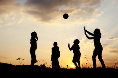 siluet, grup mutlu çocuklar oynarken çayır, günbatımı, yaz