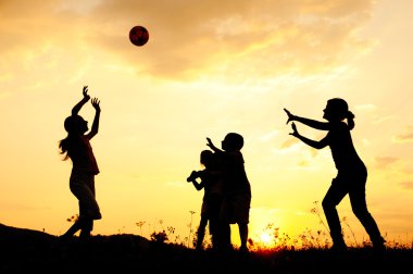 siluet, grup mutlu çocuklar oynarken çayır, günbatımı, yaz