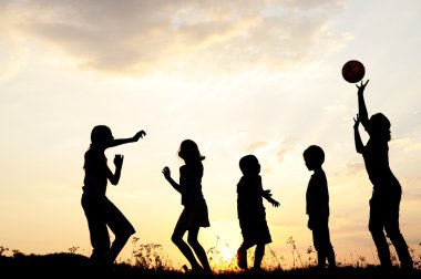 siluet, grup mutlu çocuklar oynarken çayır, günbatımı, yaz