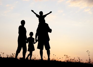 Silhouette, group of happy children playing on meadow, sunset, summertime clipart