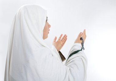 genç bir kadın, beyaz geleneksel giysiler içinde Müslüman Hacı