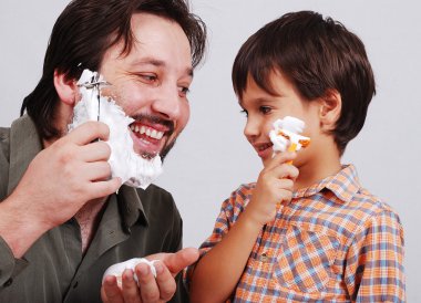 Father is teaching his boy how to shave clipart