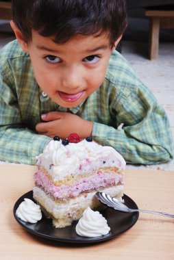 Very cute kid about to eat colorful cake, isolated clipart