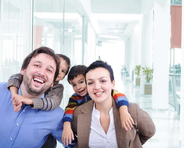 Familia joven con dos hijos en el centro comercial — Foto de Stock