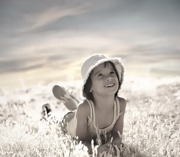 Criança feliz colocar na grama de outono — Fotografia de Stock