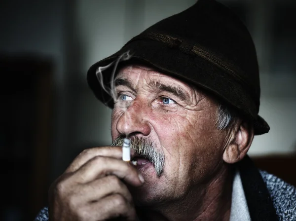 Närbild konstnärligt foto av åldern man med grå mustasch rökning, säd läggs — Stockfoto