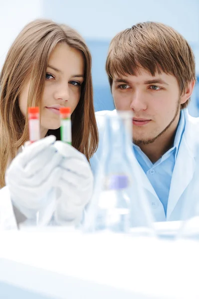 女性和男性的科学家在实验室中用试管 — 图库照片