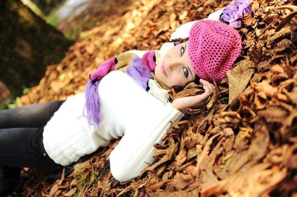 Krásná mladá dívka leží na podzim opadá listí — Stock fotografie