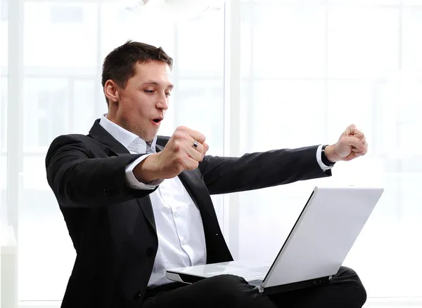 Happy executive raising fists in excitement, in front of laptop — Stock Photo, Image