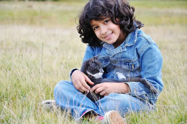 Petite fille très mignonne avec chat sur prairie — Photo