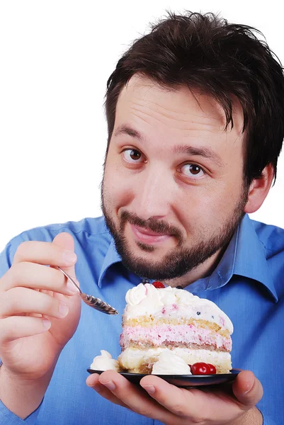 Young man eating colorful cake, isolated — Stock Photo, Image