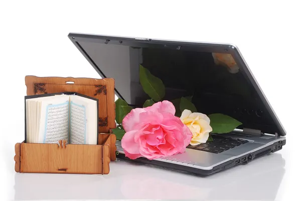Piękne róże, laptop i islam Świętej księgi, ułożyła na białym tle — Zdjęcie stockowe
