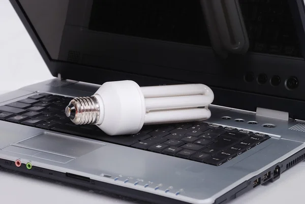 Elektrické žárovky, bílé světlo put na laptop — Stock fotografie