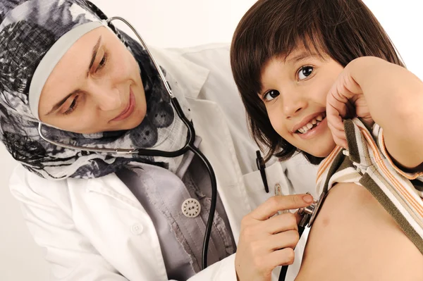 Мусульманка-врач в больнице осматривает маленького мальчика — стоковое фото
