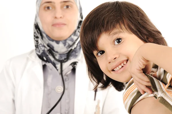 Hastanede küçük bir çocuğu muayene eden Müslüman bir kadın doktor. — Stok fotoğraf