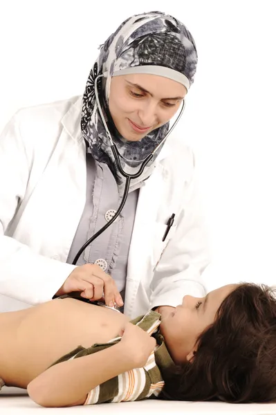 Muslim female doctor in hospital examining a little boy — Stock Photo, Image