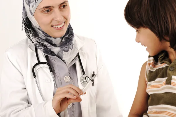 Muslim female doctor in hospital giving an injection to a little boy — Stock Photo, Image