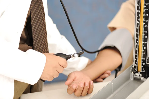 Lekarz mierzy ciśnienie u pacjenta w klinice. — Zdjęcie stockowe