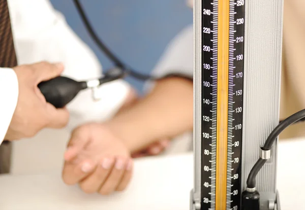 Médico mede a pressão do paciente na clínica — Fotografia de Stock