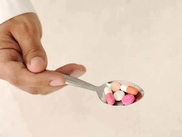 Medico con pillole in cucchiaio — Foto Stock