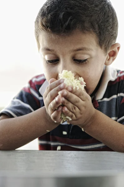 Yoksulluk, pirinç yemek yiyecek pot küçük zavallı çocuk portresi — Stok fotoğraf