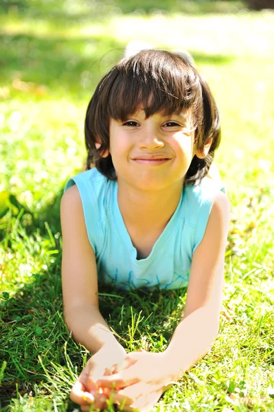 Young child laying on the grass — Stock Photo, Image