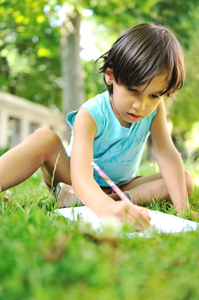 Çim yazma konusunda açık havada genç çocuk — Stok fotoğraf