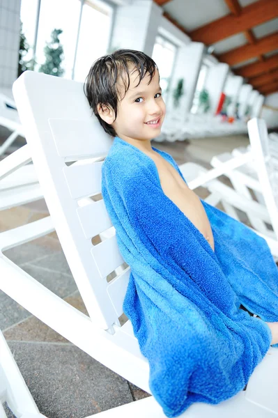 stock image Young boy laying on towel by the edge of the pool