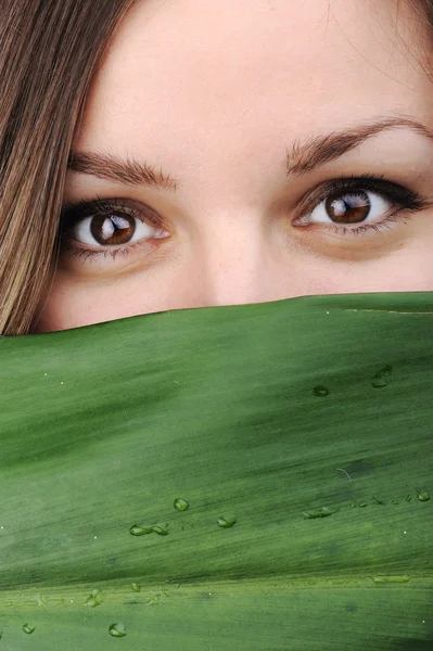 Closeup portrait of young beautiful woman with green leaf as copy space — Stock Photo, Image