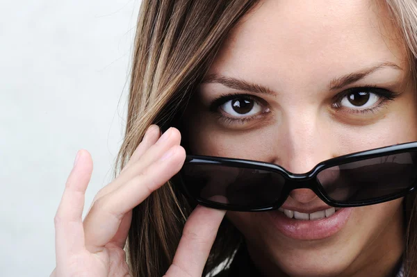 Mujer de belleza con gafas de sol en la punta de la nariz y sonriendo —  Fotos de Stock
