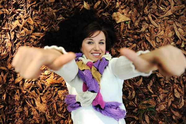 年轻漂亮的女孩躺在秋天的落叶 — 图库照片