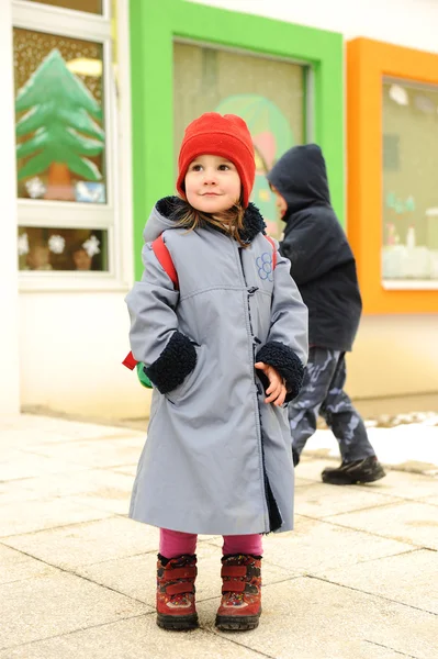 かわいい女の子、屋外保育園幼稚園の前に立って — ストック写真