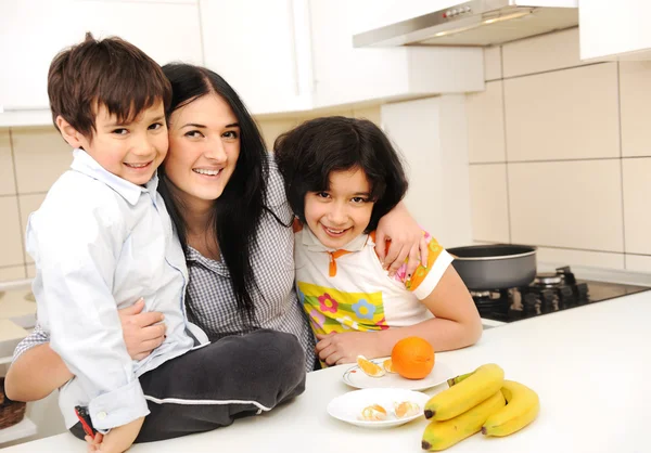 Matka a děti připravit jídlo, jídle společně — Stock fotografie