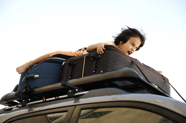 Маленький мальчик, путешествующий на крыше машины — стоковое фото