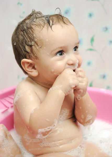 Entzückender kleiner Junge, der ein Bad mit Seifenlauge auf dem Haar nimmt — Stockfoto