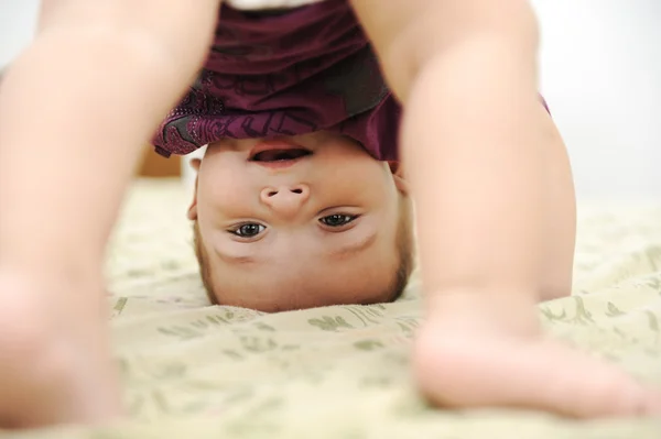 Bambino ragazzo giocare a testa in giù in camera da letto — Foto Stock