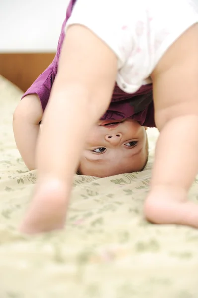 Bambino ragazzo giocare a testa in giù in camera da letto — Foto Stock