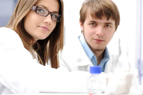 Jovens cientistas médicos que trabalham em laboratório moderno, pesquisa com tubos — Fotografia de Stock