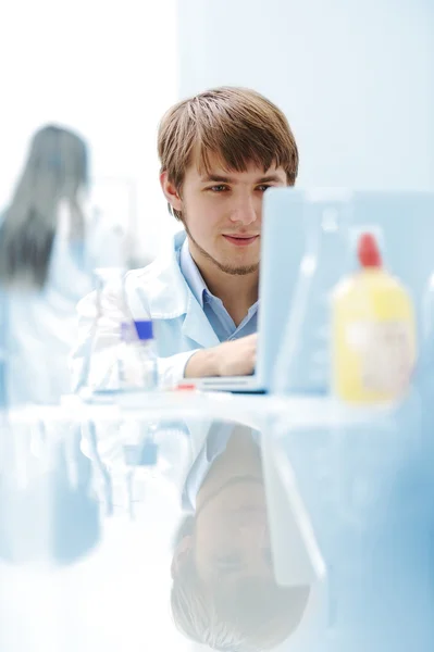 Young medical scientist working in modern lab, research with tubes and note — Stock Photo, Image