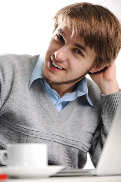Νεαρός άνδρας χρησιμοποιώντας ένα φορητό υπολογιστή. πληκτρολογώντας. φλιτζάνι καφέ δίπλα. — Φωτογραφία Αρχείου