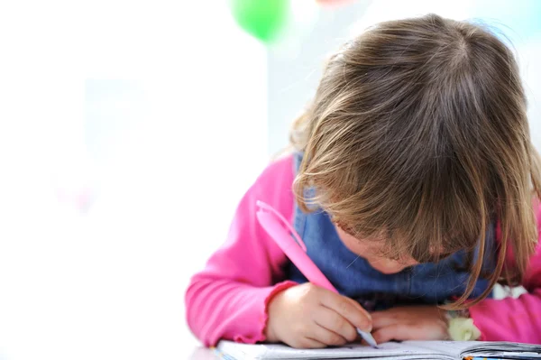 Pequeña linda niña rubia está dibujando con lápiz sobre papel, gran copia spa — Foto de Stock