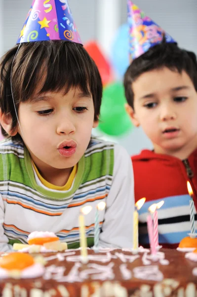 Dos niños pequeños soplando velas en la torta, feliz fiesta de cumpleaños —  Fotos de Stock