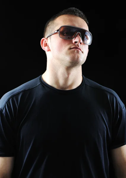 Mode élégante jeune homme portrait avec des lunettes de soleil sur fond noir — Photo