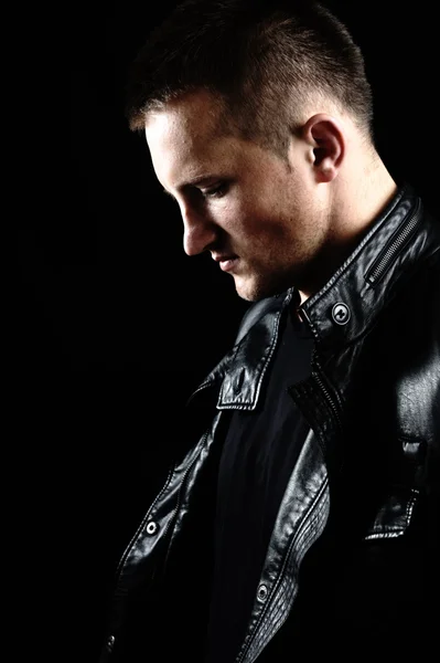 Moda con estilo joven Hombre retrato con chaqueta de cuero sobre fondo negro — Foto de Stock