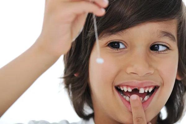Förlorad mjölk-tand, söt pojke med långt hår som håller hans tand på tråd — Stockfoto