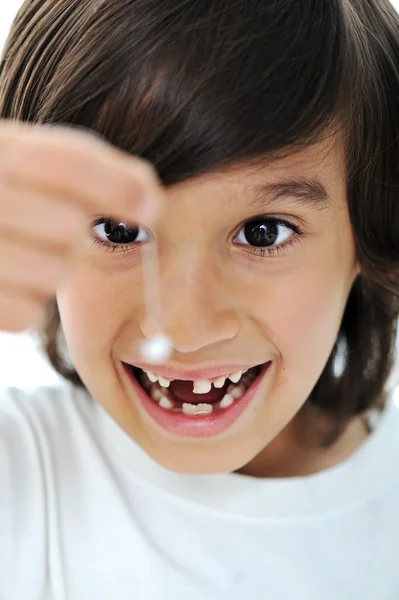 Ztracené mléka zub, roztomilý chlapec s dlouhými vlasy drží jeho zub na vlákno — Stock fotografie