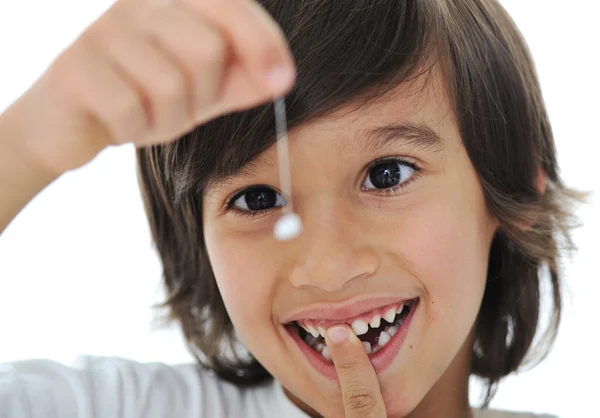Utraconych zębów mlecznych, ładny chłopiec z długimi włosami, trzymając jego zębów w wątku — Zdjęcie stockowe